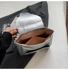 Détail du sac à dos argenté avec doublure orange chaude et poche intérieure pratique