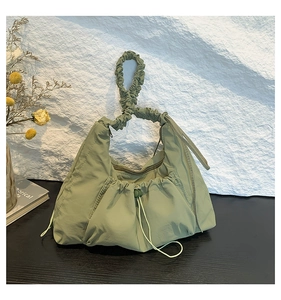 Detailed view of sage green pleated nylon tote bag with drawstring and ruched handle