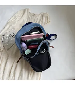 Detail of blue denim backpack showing large interior capacity for tablets and essentials