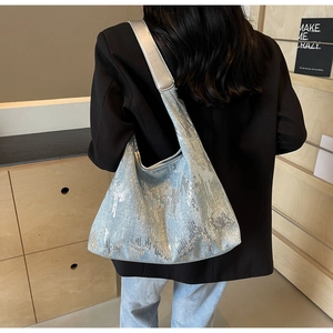 Detail of silver sequin tote bag with smooth grey shoulder strap and metallic finish