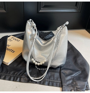 Dettaglio della borsa hobo argento con perle decorative e catena sottile in metallo