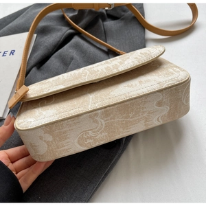 Detail view of the retro beige printed canvas bag with brown leather strap and metal buckle