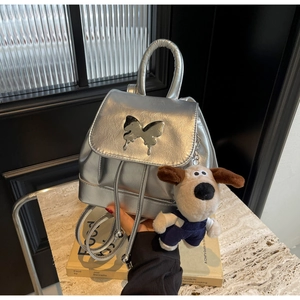 Détail du mini sac à dos argenté avec décor papillon et petit pendentif en peluche