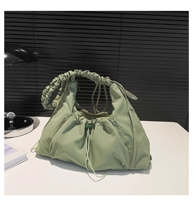 Detail of light green pleated canvas tote with drawstring design and spiral handle