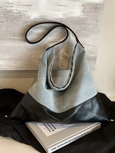 Blue denim and black leather hobo shoulder bag with bottom rivets on fashion book