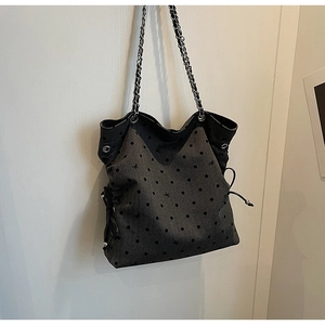 Detail of dark grey tote with bow prints, polka dots, and stylish silver chain strap