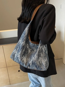 Blue and white textured jacquard tote bag with leather strap shown on a model