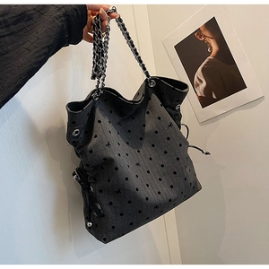 Detail of grey polka dot tote bag with silver chain strap and drawstring closure