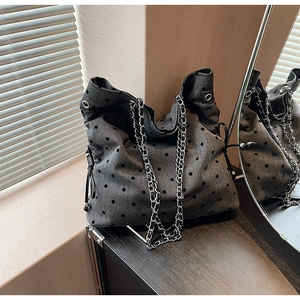 Detail of dark grey canvas tote with black polka dots and silver chain shoulder strap