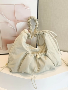 Minimalist beige pleated canvas tote bag with drawstring closure and scrunchie handle