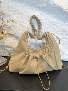 Beige pleated nylon tote bag with ruffle strap and drawstring detail for daily casual wear