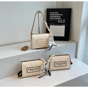 Detail of cream rectangular PU handbags with decorative scarves and adjustable straps