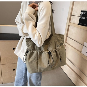 Detail of olive green canvas tote bag with multi-pocket drawstring design for storage