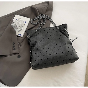Detail of grey polka dot tote bag with silver chain strap and drawstring closure