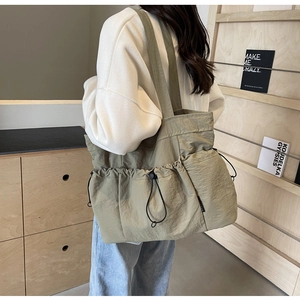 Detail of olive green canvas tote bag with functional drawstring pockets and twin straps