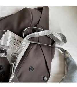 Detail view of silver crossbody bag with adjustable long strap and zipper closure
