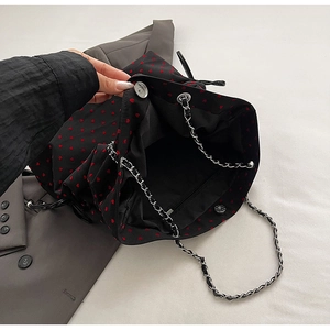 Detail view of the black heart print tote bag showing magnetic buckle and inner pocket