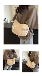Detail of beige crescent bag with detachable coin purse and woven zipper pull
