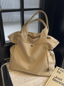 Minimalist apricot large canvas tote bag with adjustable black side drawstrings and metal snap