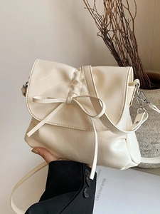 Chic cream-white pleated bucket bag with bow detail and silver-tone hardware