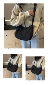 Detail of black nylon crescent crossbody bag with adjustable strap and small coin purse