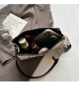 Detail view of the spacious inner compartments of the cream shoulder bag for essentials