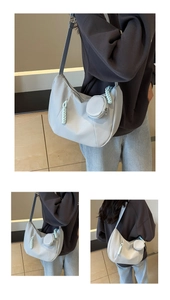 Detail of light blue hobo bag with adjustable strap and detachable round coin purse charm