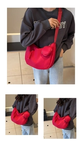 Detail of red crescent crossbody bag with adjustable strap and matching round charm