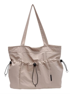 Large beige canvas tote bag with multi-pocket drawstring design and soft shoulder straps