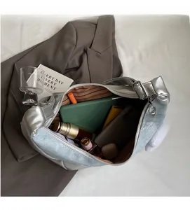 Internal view of a spacious denim and silver leather patchwork bag holding a tablet