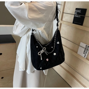 Détail du sac en velours noir avec chaînes argentées, perles et cristaux en cœur