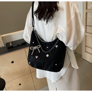 Détail du sac hobo noir avec chaîne argentée, perles et pierre précieuse cœur rose