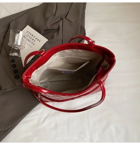 Interior view of red quilted tote bag showing large capacity and zipper pocket