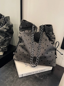 Grey fabric tote bag with polka dots and bows featuring a chain strap and drawstring