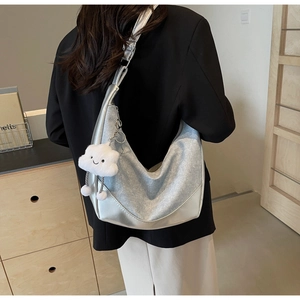Silver crescent hobo bag with denim patchwork and white plush cloud charm on model