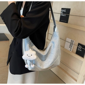 Silver metallic hobo bag with plush cloud charm styled on a model in a black blazer