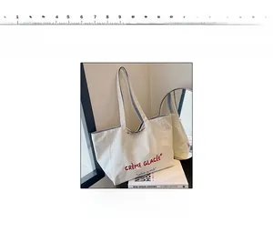 Close-up of white canvas tote bag featuring red and blue embroidered Crème Glacée text