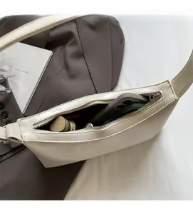Interior view of the cream PU leather shoulder bag holding a smartphone and cosmetics