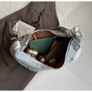 Interior view showing the large capacity of a denim patchwork hobo bag with daily essentials