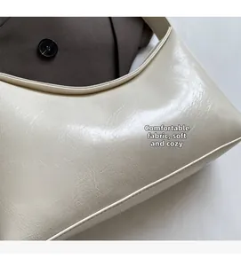 Close-up of soft cream white leather handbag with natural folds and smooth texture