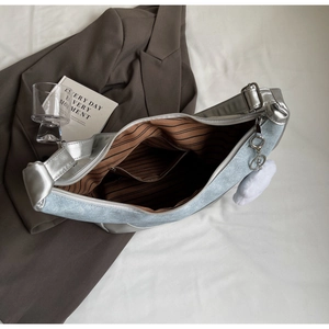 Internal view of silver-blue hobo bag featuring striped lining and zipper pocket