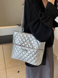 Silver quilted tote bag with metallic finish and long shoulder straps for daily commute
