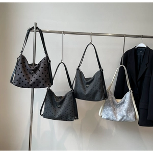 Detail view of multi-pattern canvas hobo bags with metallic bow accents and slim straps