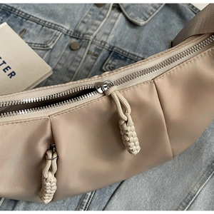 Detail of khaki crescent bag with ruched nylon fabric and braided rope zipper pulls