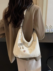 Sac fourre-tout blanc plissé avec chaîne de perles et nœud porté sur l'épaule