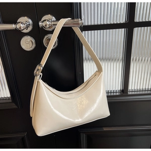 Detalle de bolso hobo en pomo negro con textura de cuero brillante y hebilla plateada