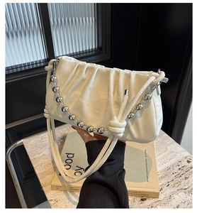 Detail der weißen gefalteten Cloud-Bag mit Perlenkette und geknotetem Lederriemen
