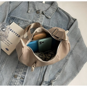 Top view of spacious dumpling bag interior with phone and wallet on denim jacket