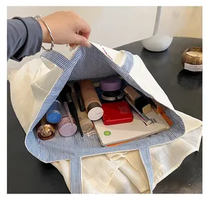 Top view of spacious canvas tote bag with blue stripe lining showing items inside