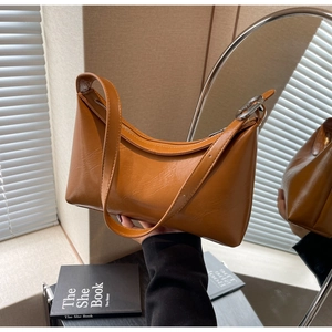 Detalle de bolso hobo color caramelo con anillo de metal plateado y cremallera